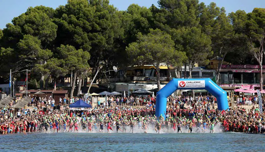 Hundreds of athletes jumping into the water as the start goes for Challenge Peguera