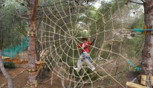 A girl climbing the spider net in Jungle Parc Junior